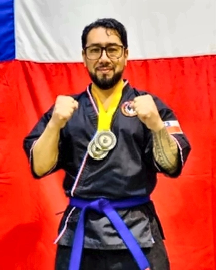 Sensei Alejandro Rojas Rifo con sus medallas frente a la bandera de Chile